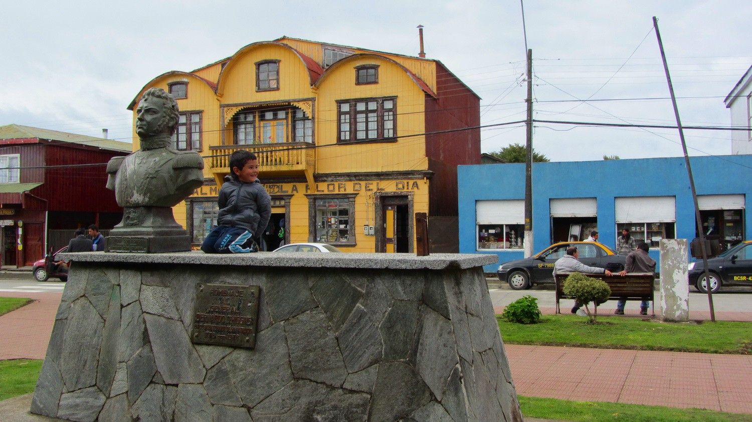 Boy with Bernardo O'Higgins, the Chilean National Hero. Yellow front of a hardware and flower store of Maulin in the background.
